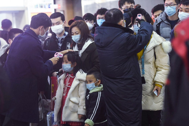 Lực lượng chức năng kiểm tra thân nhiệt hành khách đến tỉnh Chiết Giang, Trung Quốc /// AFP