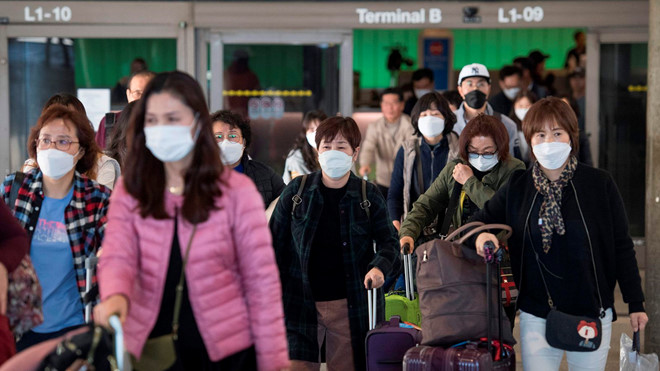 Hành khách mang khẩu trang khi đáp chuyến bay từ châu Á đến sân bay Los Angeles, Mỹ ngày 29.1 /// AFP