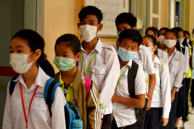 Học sinh mang khẩu trang y tế khi vào lớp học /// AFP