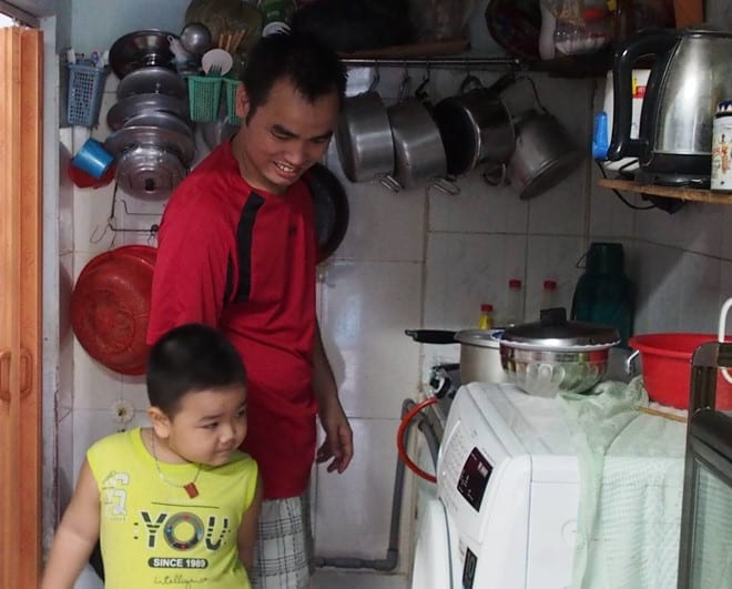 Anh Trần Văn Phố đang nấu cơm trưa cho 2 con nhỏ tại phòng trọ /// Ảnh: Song Mai 
