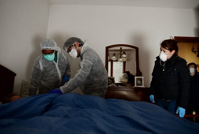 Các nhân viên y tế đến nhà khám một bệnh nhân nghi nhiễm Covid-19 tại Ý /// AFP