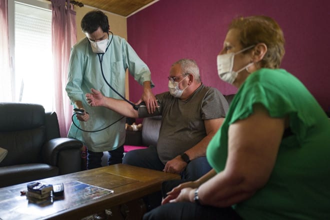 Nhân viên y tế kiểm tra huyết áp một bệnh nhân nghi nhiễm Covid-19 tại Pháp /// AFP
