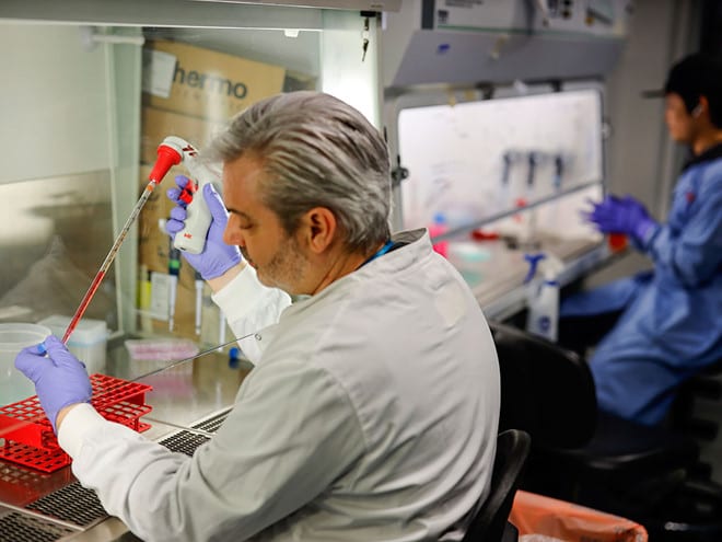 Các nhà khoa học nghiên cứu vắc xin Covid-19 tại một phòng thí nghiệm ở Anh /// Ảnh: AFP