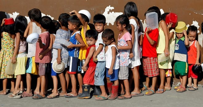 Trẻ em xếp hàng nhận cháo miễn phí tại Manila, Philippines /// Reuters