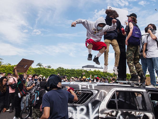 Người biểu tình phá hủy xe cảnh sát ở Los Angeles, bang California /// AFP