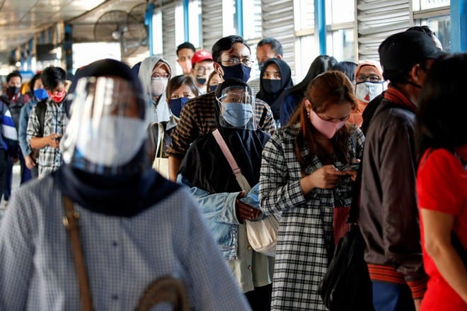 Hành khách đeo khẩu trang đề phòng Covid-19 tại trạm xe buýt ở Jakarta, Indonesia /// Reuters