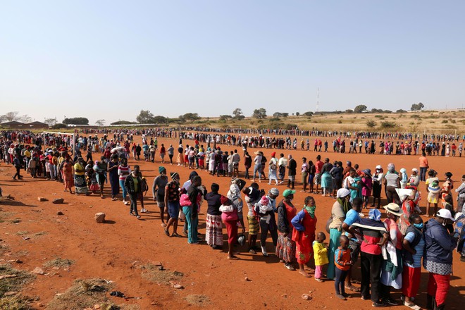 Người dân xếp hàng chờ nhận lương thực từ thiện tại Nam Phi /// Ảnh: Reuters