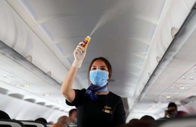 Một tiếp viên phun thuốc khử trùng trên chuyến bay tại Ai Cập /// Reuters