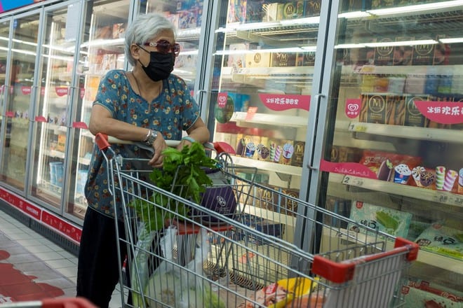 Một phụ nữ trước khu thực phẩm đông lạnh tại một siêu thị ở Bắc Kinh, Trung Quốc /// Reuters