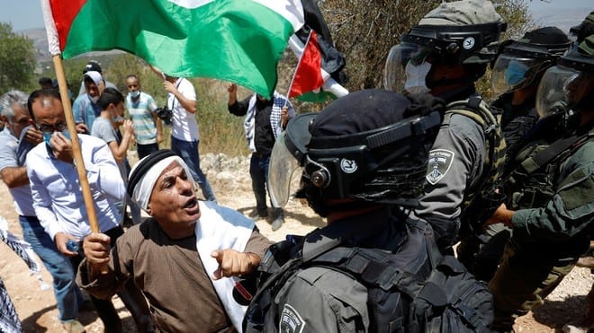 Người dân Palestine phản đối việc sáp nhập trong một lần đối đầu với các binh sĩ Israel /// Reuters