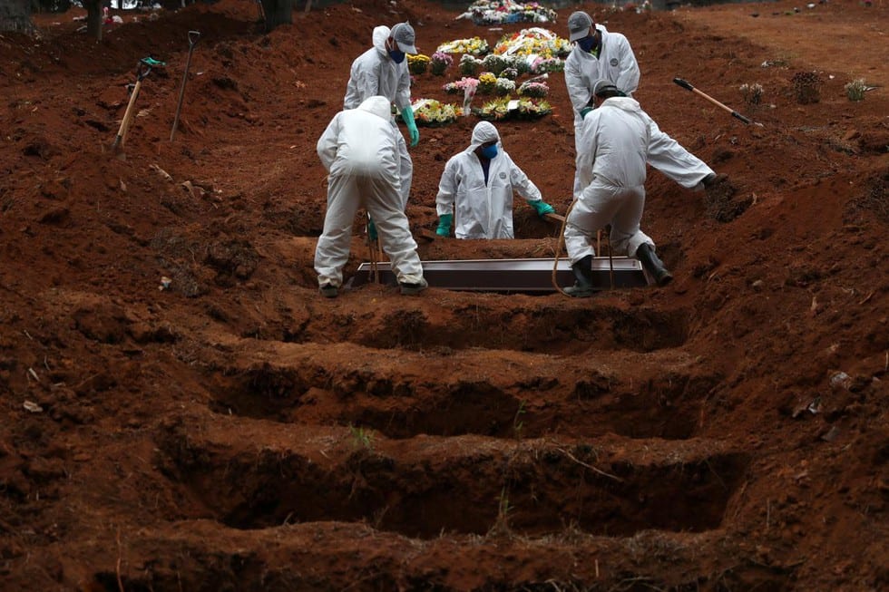 Nhân viên mai táng mặc trang phục bảo hộ đang chôn cất một người chết vì Covid-19 tại nghĩa trang Sao Luiz ở Sao Paulo, Brazil, hôm 4.6 /// Reuters