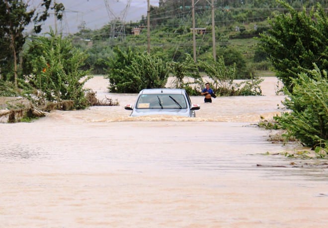 Chiếc ô tô vượt qua dòng nước lũ tại cầu Ba Khe (xã Đại Đồng, H.Đại Lộc, Quảng Nam) /// ẢNH: MẠNH CƯỜNG