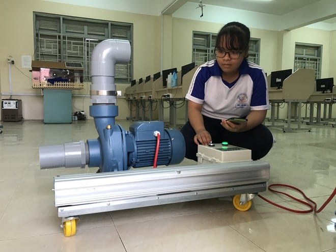 Trần Thị Cẩm Ngọc khởi động máy điều khiển thiết bị từ xa được gắn với máy bơm nước /// Ảnh: Duy Tân