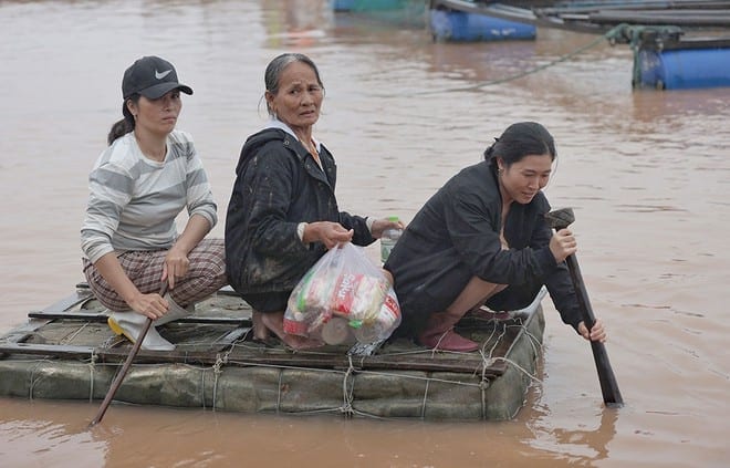 Người dân vùng lũ lụt tại xã Quảng Minh, H.Quảng Trạch (Quảng Bình) sử dụng phương tiện tự chế để đi nhận hàng cứu trợ ẢNH: NGỌC DƯƠNG