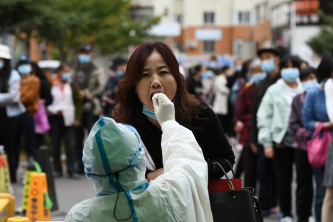 Nhân viên y tế xét nghiệm Covid-19 cho một phụ nữ trong đợt xét nghiệm toàn thành phố Thanh Đảo (Trung Quốc) ngày 13.10 /// Reuters