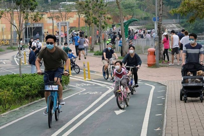 Người dân đeo khẩu trang đạp xe trong đại dịch Covid-19 ở Hồng Kông /// Reuters