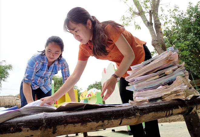 Cô giáo Trường mầm non Phong Bình 2 (Thừa Thiên-Huế) tranh thủ nắng phơi những chồng tài liệu bị ướt, mốc do ngâm lũ /// ẢNH: ĐÌNH TOÀN