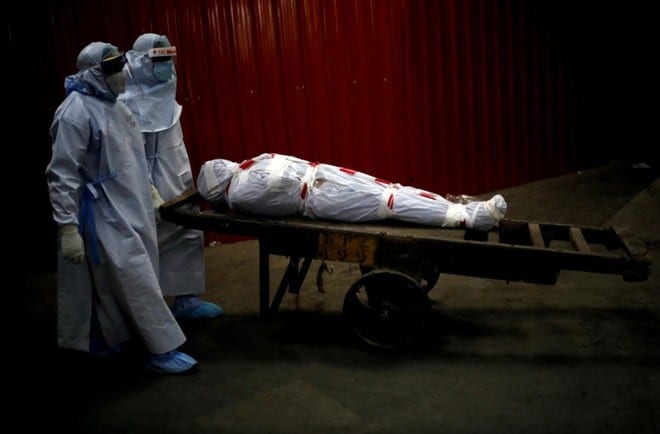 Nhân viên y tế đưa thi thể một bệnh nhân Covid-19 đến nhà hỏa táng ở Ấn Độ /// Reuters