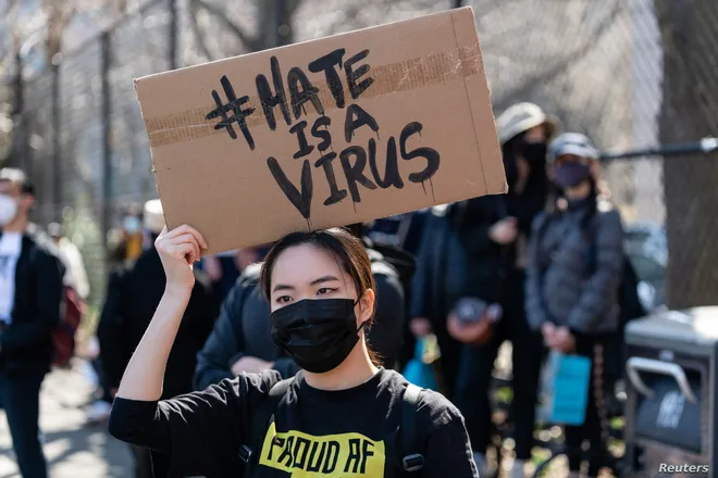 Người tham gia một cuộc biểu tình phản đối kỳ thị người gốc Á, mang theo biểu ngữ với nội dung "Hận thù là virus" /// Reuters