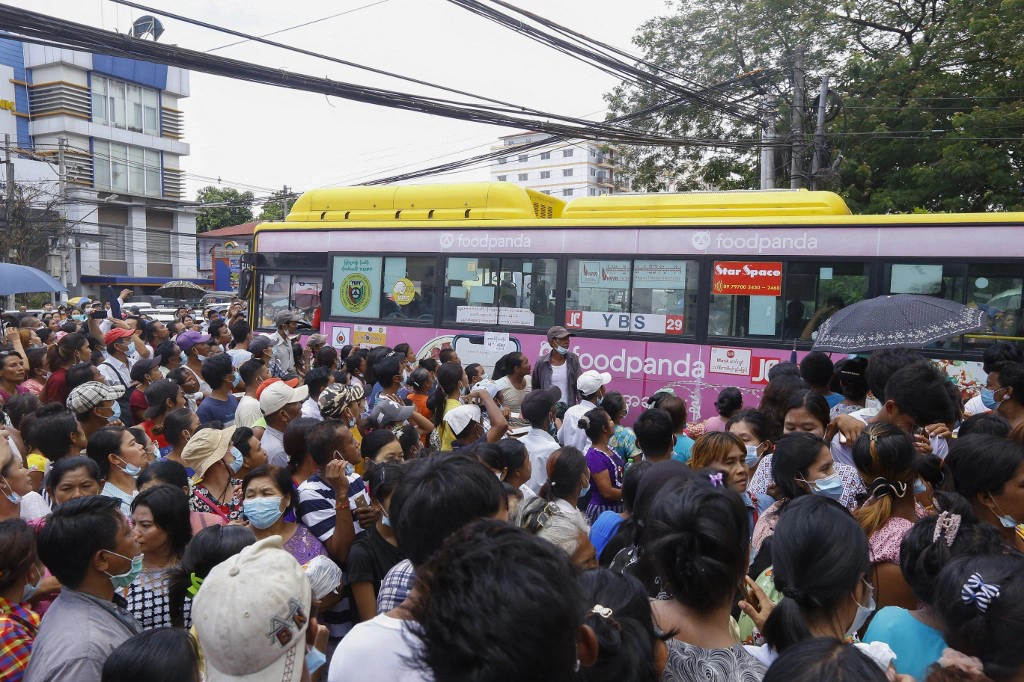 Người dân vây quanh một xe buýt chở các phạm nhân được thả tại Yangon /// AFP