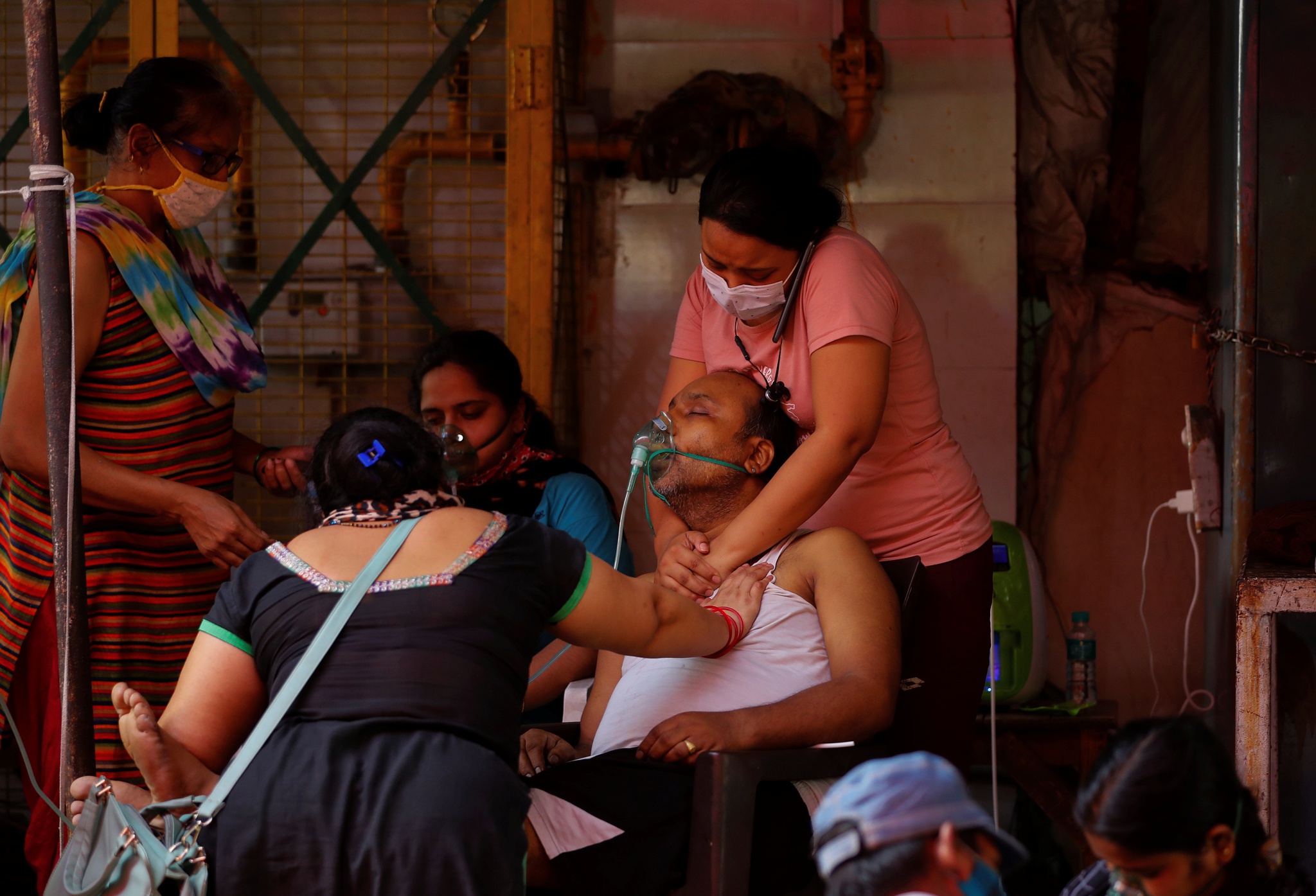Một bệnh nhân Covid-19 bất tỉnh trong vòng tay người thân ở Ấn Độ /// Ảnh: Reuters