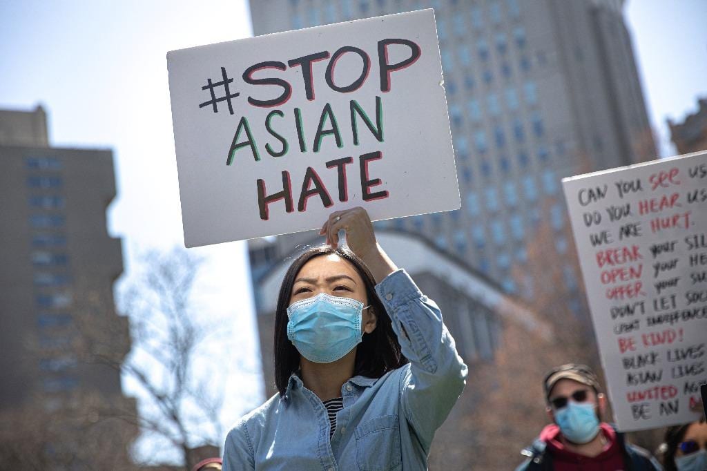 Một phụ nữ giơ cao tấm bảng "Ngừng ngay hành động thù hằn gốc Á" trong một cuộc biểu tình ở thành phố New York vào đầu tháng 4 /// REUTERS