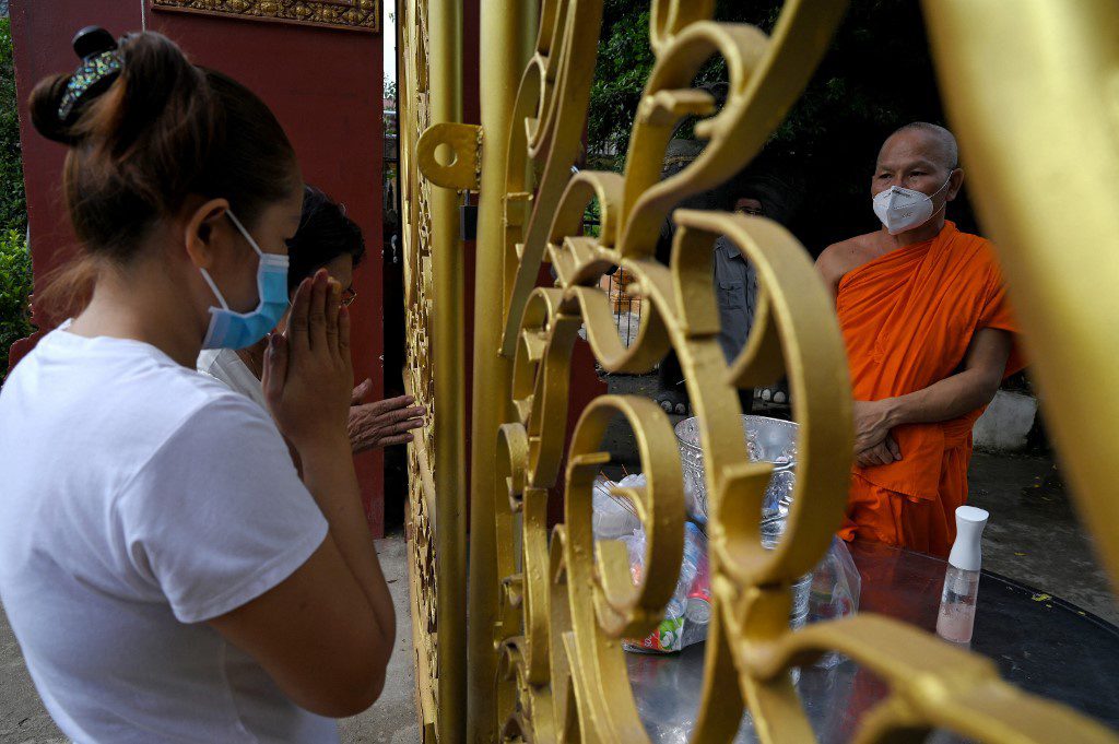 Phật tử cúng dường tại một ngôi chùa ở Phnom Penh, Campuchia /// AFP