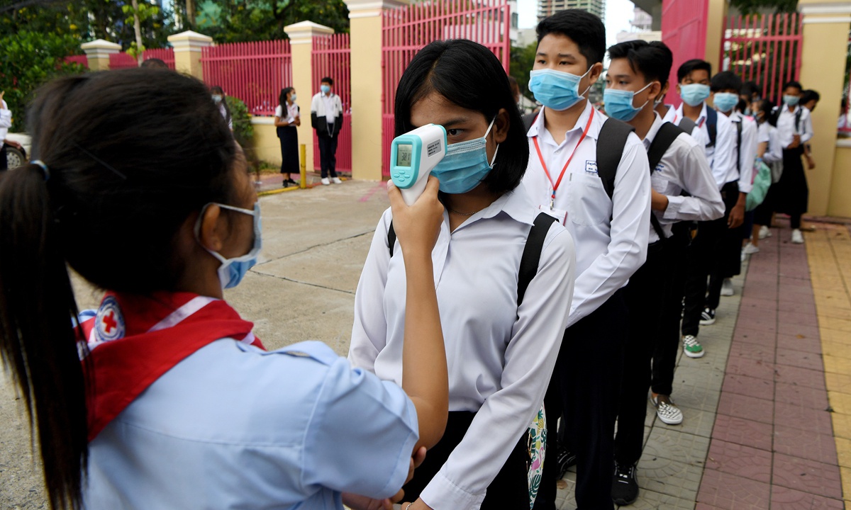 Học sinh đeo khẩu trang, được đo nhiệt độ tại một trường học ở Phnom Penh hồi tháng 9.2020 /// AFP