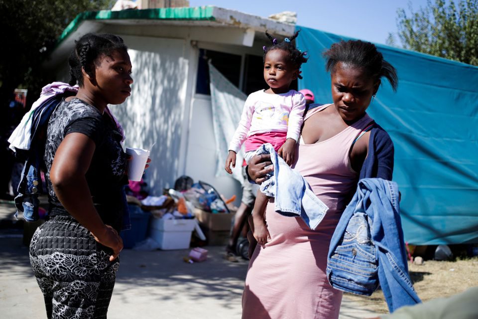 Người di cư phân loại quần áo được quyên góp ở Ciudad Acuna (Mexico) gần biên giới với Mỹ vào ngày 23.9 /// REUTERS