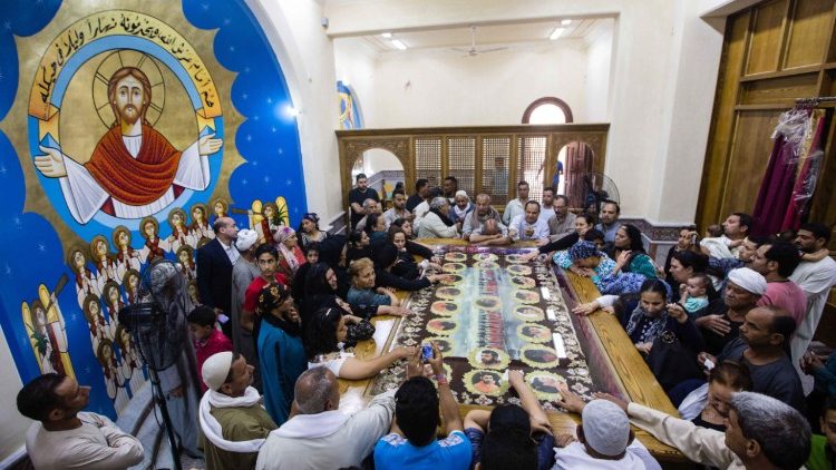 Người thân quy tụ xung quanh chân dung của 20 tín hữu Chính Thống Coptic người Ả Rập đã bị chiến binh Nhà nước Hồi giáo chặt đầu trên bãi biển ở Libya vào năm 2015.